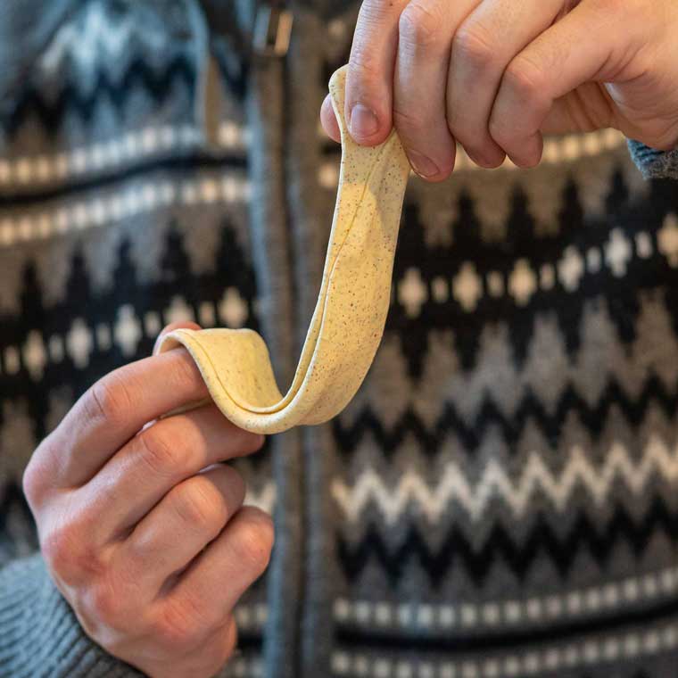 Two hands stretching yellow Gingersnapper Thinking Putty®.