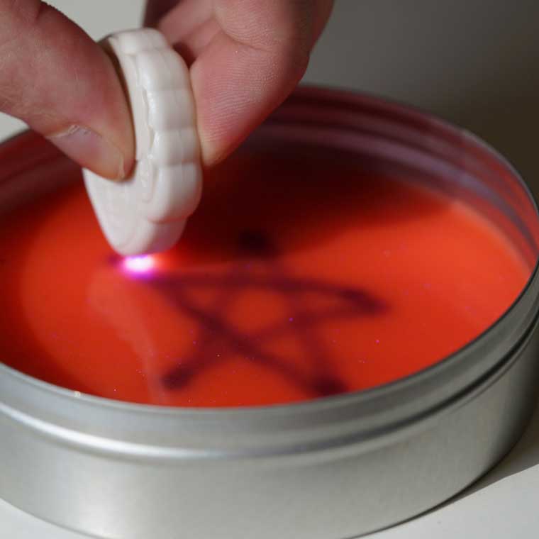 Hand drawing on putty with Crazy Aaron's Glow Charger®.