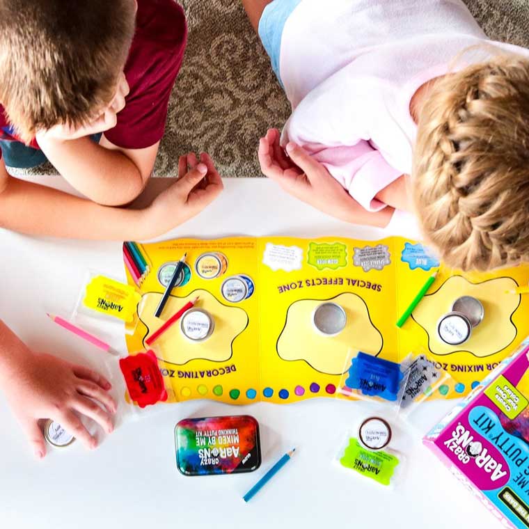 Seen from above, two children reading through instruction mat. 