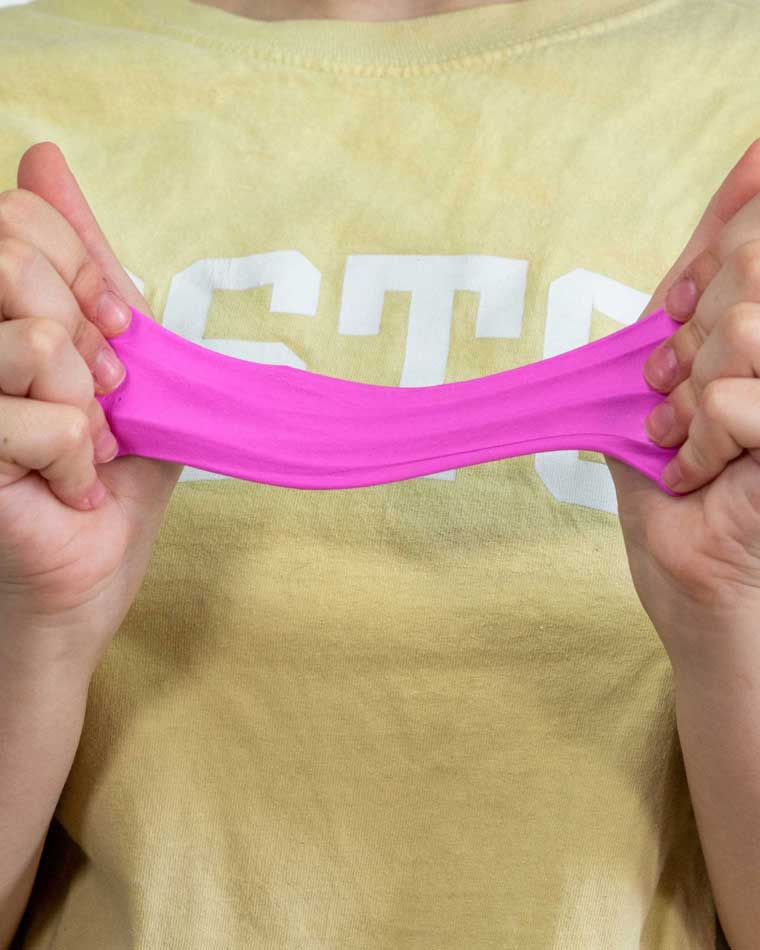 Two hands stretching violet color putty.