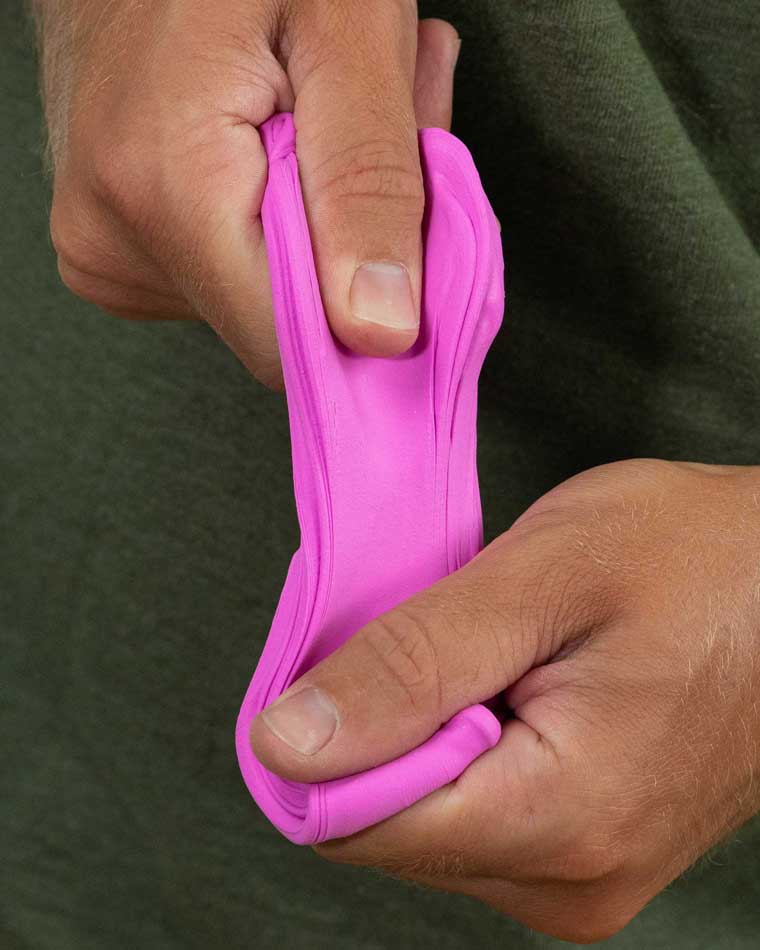 Two hands pulling violet color putty.