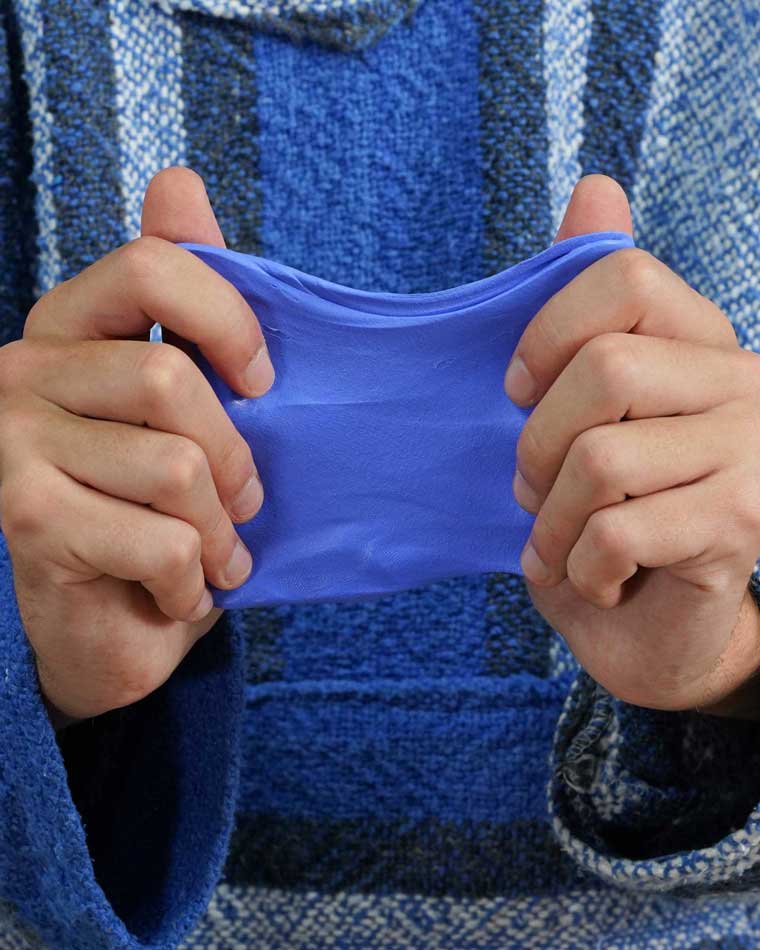 Two hands stretching blue color, berry scented putty.