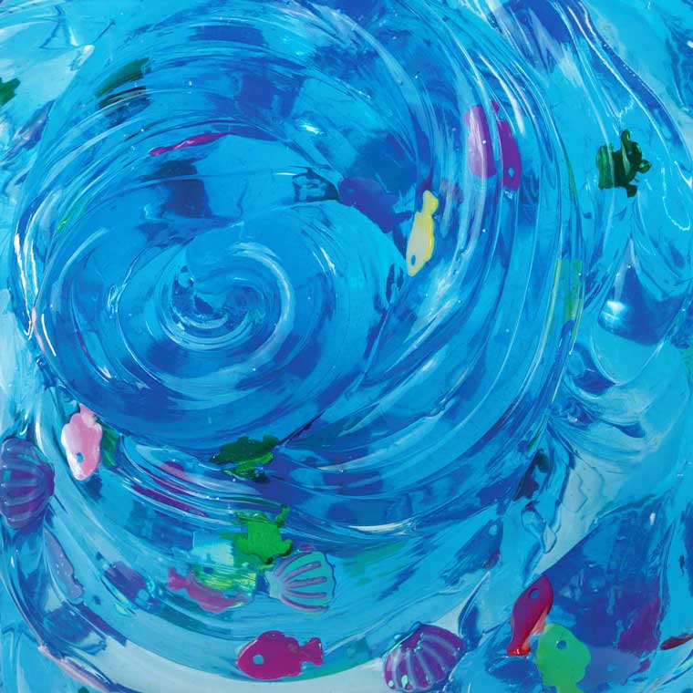 Close up detail of translucent blue putty with sea creature shaped pieces in it.