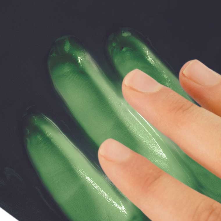 Hand leaving a green handprint in purple heat sensitive putty.