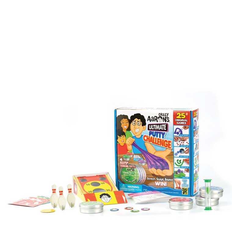 Ultimate Putty Challenge game box on a table with, putty tins, timer, game cards and pieces.