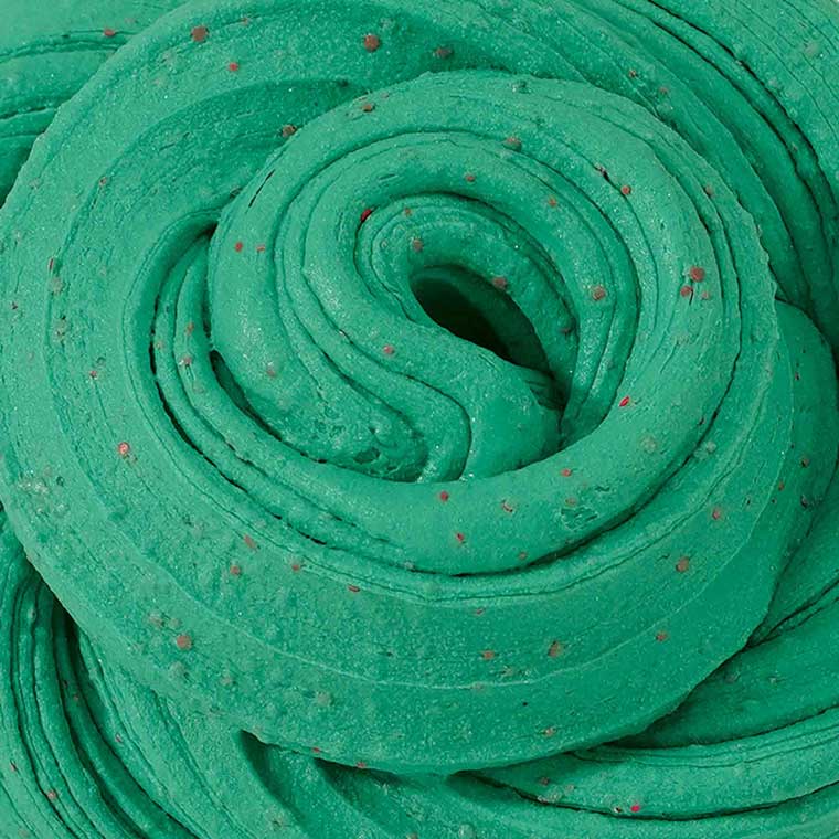 Close up texture of green putty with red speckles.