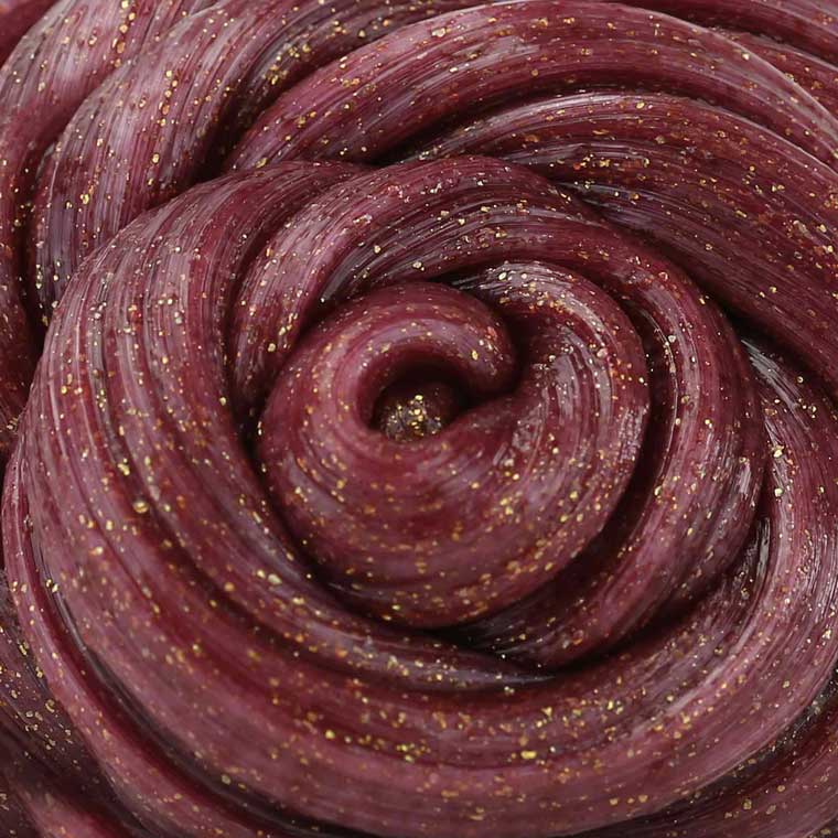 Close up texture of red putty that has gold sparkles.